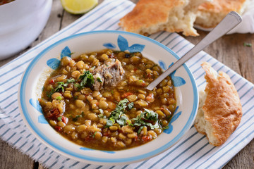Delicious country soup from a mixture of legumes in a plate is ready to be eaten for lunch
