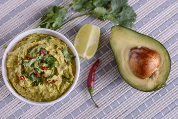 Appetizing guacamole sauce from avocado pulp with the addition of cilantro, lime juice and other vegetables and seasonings is ready for use