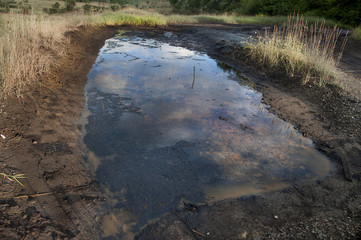 Spills of crude oil on the soil surface. Ecological problems of oil production. Environment pollution