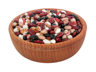 Useful, delicious natural food of village production. Beans of different colors, colorful, in a wooden plate on a white isolated background. 