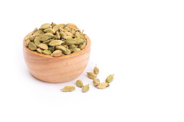 Green Cardamom in wooden bowl, cardamon or cardamum  isolated on white background (dried fruits of Elettaria cardamomum