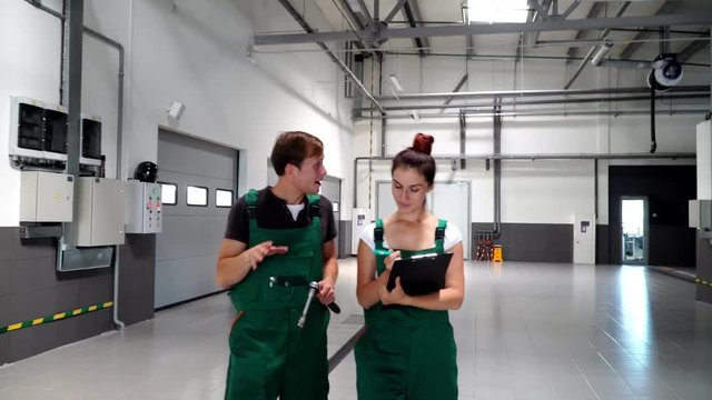 Two auto mechanics, go through the service, look at the serviceability of the car wheel. 