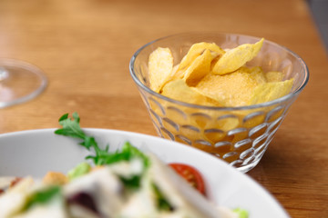 Vase with chips near plate on wooden table