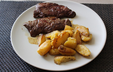 une assiette de pomme de terre avec deux steack

