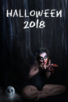 Gruselige Frau im Wald mit Totenkopf und blutiger Maske und Aufschrift "Halloween 2018"