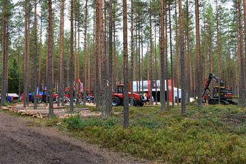 Fototapeta na wymiar Volvo and Nisula heavy equipments were displayed in the forest with some logs during the FinnMetko exhibit in Jämsänkoski, Finland.