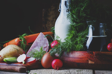 Ingredients for cold soup with vegetables, herbs and meat products, old wooden table, selective focus