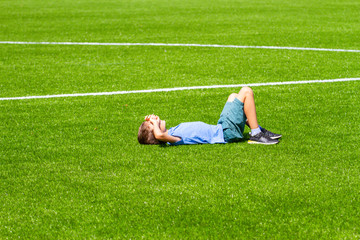 Boy lying on the football field