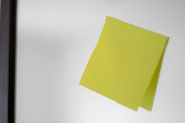 Yellow empty note hanging at the mirror board