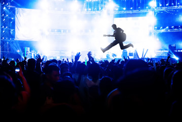 Blurred image of concert Crowd Cheering fans during live music with singer song on stage