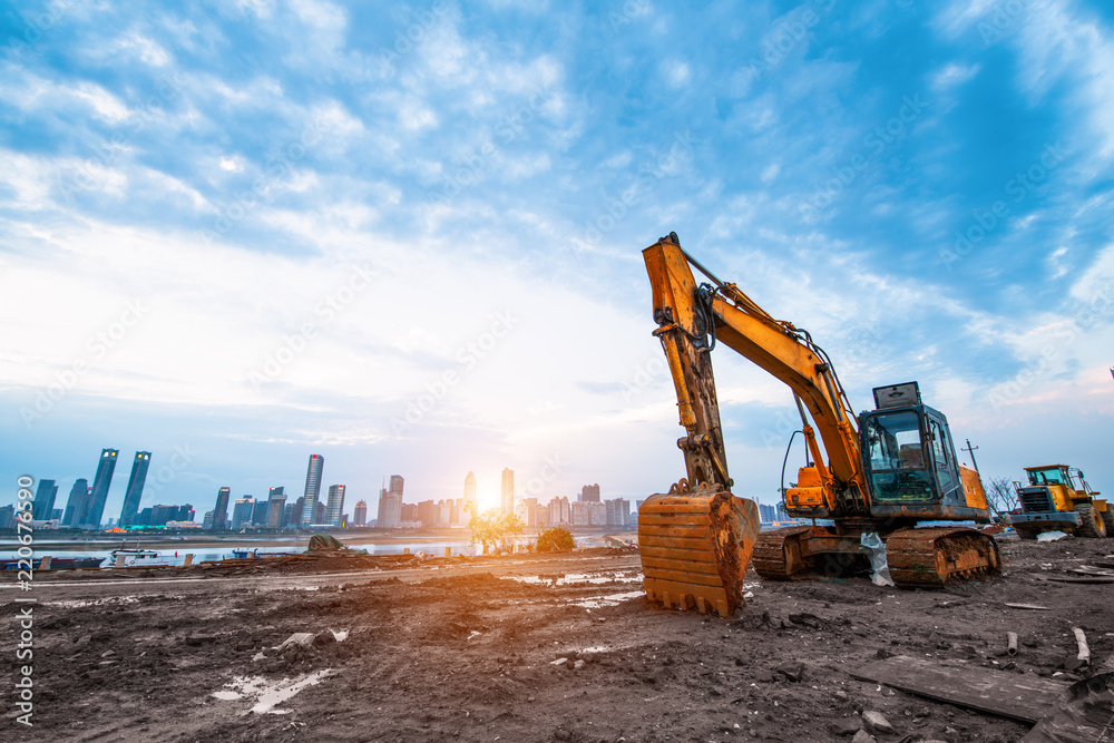 Wall mural excavator in construction site on sunset sky background - Wall murals