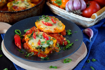 Two halves of stuffed bell peppers on a dark plate