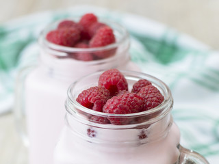 Raspberry yogurt on a wooden table. 