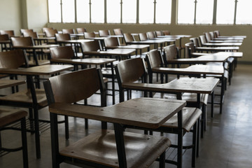 Empty classroom with vintage tone wooden chairs. Back to school concept.