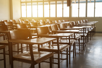 Empty classroom with vintage tone wooden chairs. Back to school concept.