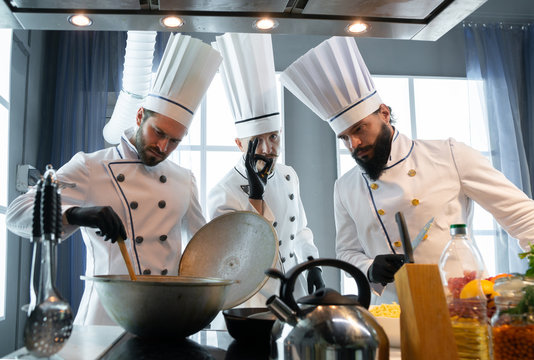 Three chefs at a restaurant near the stove