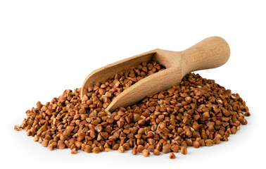 Pile of buckwheat and wooden spoon on a white, isolated.