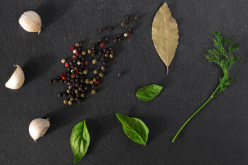 Garlick fennel pepper of basilic on a black stone background