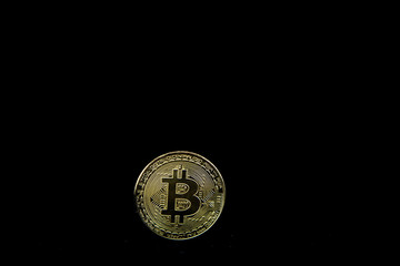 Gold coin bitcoin isolated on black background with reflection. Cryptocurrency concept with copy space.