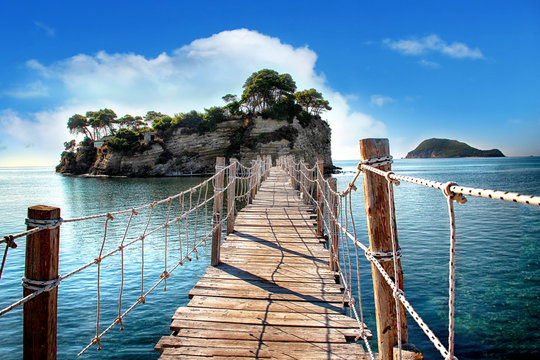 Fototapeta Drewniany most z widokiem na morze prowadzi na wyspę z palmami. To most linowy. Znajduje się w Zakynthos, Grecja.