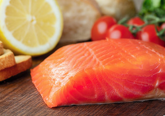 raw salmon fillet on wooden background with vegetables