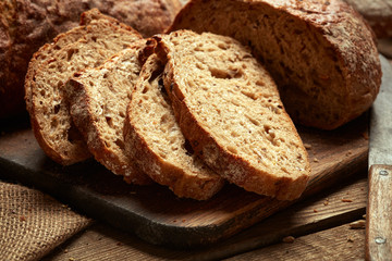 sliced fresh baked bread on wooden background