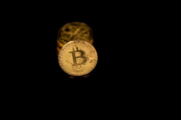 Stack of golden bitcoins isolated on black background with reflection. Cryptocurrency concept with copy space.