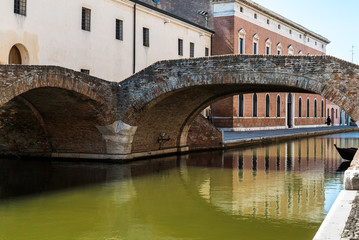 Fototapeta na wymiar alte Brücke über einen Kanal in Comacchio, Italien