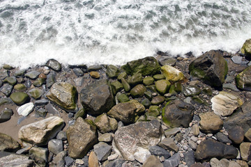 A view of rocks and stones at the Malibu beach from an high angle view for backgrounds or wallpapers in summer time
