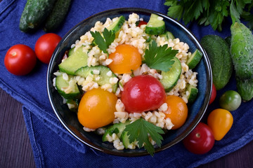 Tabbouleh salad with bulgur, cucumbers and tomatoes. Middle Eastern cuisine meal