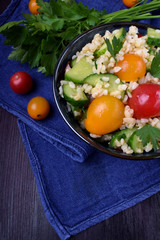 Tabbouleh salad with bulgur, cucumbers and tomatoes. Middle Eastern cuisine meal