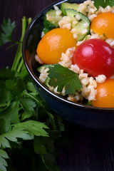 Tabbouleh salad with bulgur, cucumbers and tomatoes. Middle Eastern cuisine meal