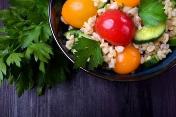Tabbouleh salad with bulgur, cucumbers and tomatoes. Middle Eastern cuisine meal
