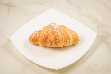croissants in a white plate/croissants in a white square plate on a marble background. Selective focus