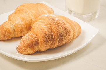 croissants in a white plate on a white table/croissants in a white square plate on a white table. Selective focus