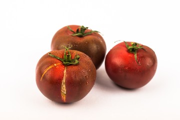 Three dark tomato on white.