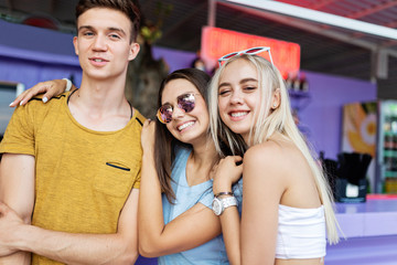 A company of good-looking friends laughing and socialising at the bar in the nice summer cafe. Cheers. Entertainment, having good time. Friendship.