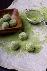 Ball sweets covered with matcha tea powder on a parchment paper. Healthy nutrition