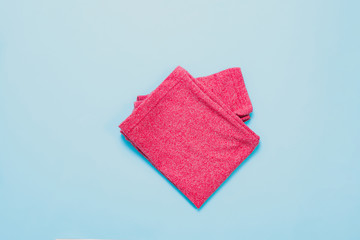 Top view of a children's red blouse, shirt on a pastel blue background. The concept of children's clothes.