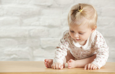 Naklejka premium Portrait of a cute baby girl sitting in the room