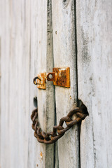 rusty chain locking an old wood door in a french village