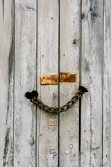 rusty chain locking an old wood door