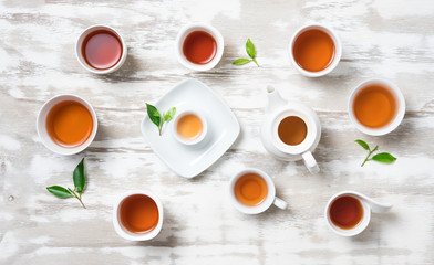 Tea concept,Teapot and cup of herbal tea with green tea leaves on wood,top view