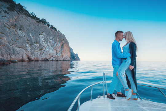 Couple lovers kissing on a Yacht. Luxury vacation on the Boat young man and woman. Sailing in the Sea.