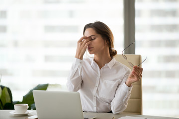 Fatigued businesswoman taking off glasses tired of computer work, exhausted employee suffering from...
