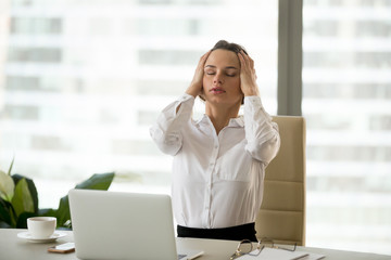 Stressed exhausted businesswoman having strong headache at work holding head in hands, frustrated...