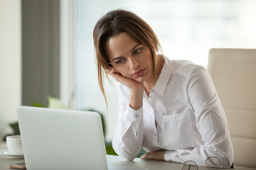 Thoughtful businesswoman thinking searching new ideas looking at laptop, serious employee feeling bored with dull monotonous online office work, employee disinterested in doing boring computer task