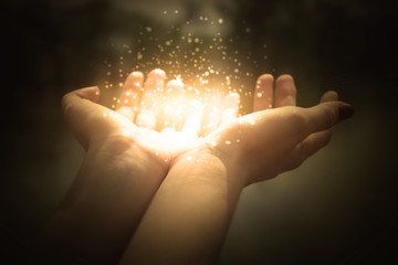 magic particles on the palms of a woman, a stream of magical energy emanating from female hands - 220690132