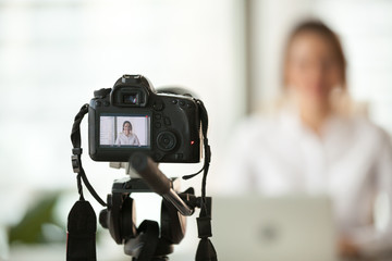 Professional dslr digital camera filming live video blog interview or vlog of woman vlogger coach...