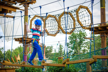 happy boy on the zip line. proud of his courage the child in the high wire park.